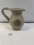 A GLYNDEBOURNE GLAZED POTTERY PITCHER JUG WITH APPLIED COAT OF ARMS. 20 CMS.