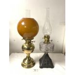 A VICTORIAN IRON-BASED OIL LAMP WITH A GLASS FRONT, AND A LATER BRASS OIL LAMP WITH SHADE.
