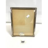 A WHITE METAL PHOTO FRAME WITH ORNATE CORNERS; 22.5 X 27.5 CMS