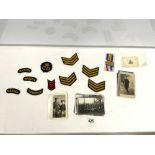 A QUANTITY OF 1ST WORLD WAR PHOTOGRAPHIC POSTCARDS, THREE MEDAL RIBBONS AND CLOTH PATCHES,