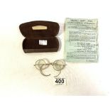 A PAIR OF ANTIQUE YELLOW METAL FRAMED SPECTACLES IN LEATHER CASE