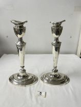 A PAIR OF ANTIQUE OVAL WHITE METAL CANDLESTICKS, 30CMS.