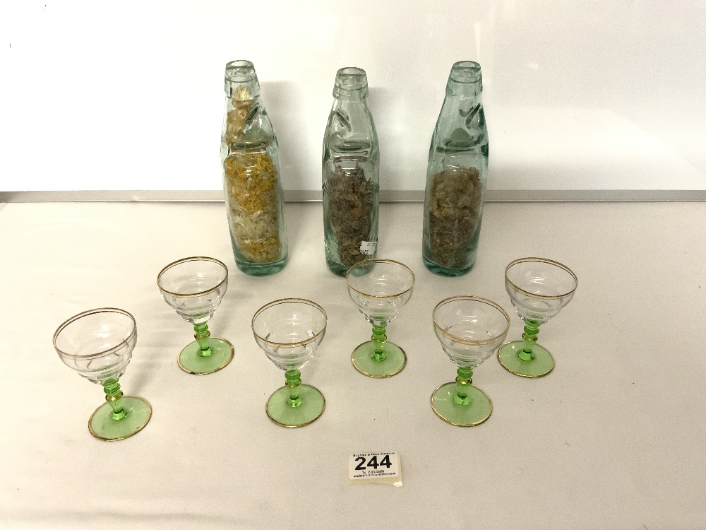 A SET OF SIX SHERRY GLASSES AND THREE VINTAGE GLASS COD BOTTLES.