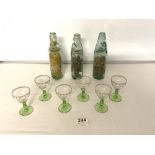 A SET OF SIX SHERRY GLASSES AND THREE VINTAGE GLASS COD BOTTLES.