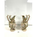 A PAIR OF COALBROOKDALE STYLE EWER JUGS WITH PUTTI AND FLORAL ENCRUSTED DECORATION; 23 CMS.