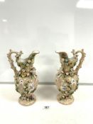 A PAIR OF COALBROOKDALE STYLE EWER JUGS WITH PUTTI AND FLORAL ENCRUSTED DECORATION; 23 CMS.