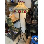 A VICTORIAN TELESCOPIC IRON LAMP STAND WITH A TIFFANY STYLE SHADE.