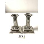 A PAIR OF HALLMARKED SILVER CORINTHIUM COLUMN CANDLESTICKS ON STEPPED SQUARE BASES, 12 CMS,