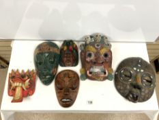 SIX CARVED AND DECORATED INDONESIAN MASKS.