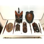 CARVED WOODEN TRIBAL WALL MASKS AND WOODEN KNIVES.