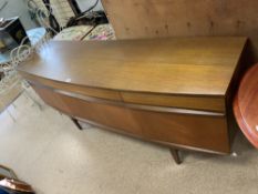 A MID CENTURY TEAK BOW FRONTED SIDEBOARD BY - EON.