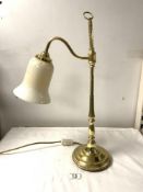 A POLISHED BRASS ADJUSTABLE DESK LAMP WITH A GLASS SHADE. 54CMS.