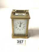 A BRASS CARRIAGE CLOCK WITH WHITE ENAMEL DIAL, [ WORKING ] 12CMS.