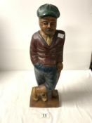 A CARVED AND PAINTED WOODEN FIGURE OF A GOLFER, 46CMS.