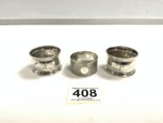 A PAIR OF HALLMARKED SILVER NAPKIN RINGS AND A HALLMARKED ENGINE TURNED NAPKIN RING, 45 GRAMS.