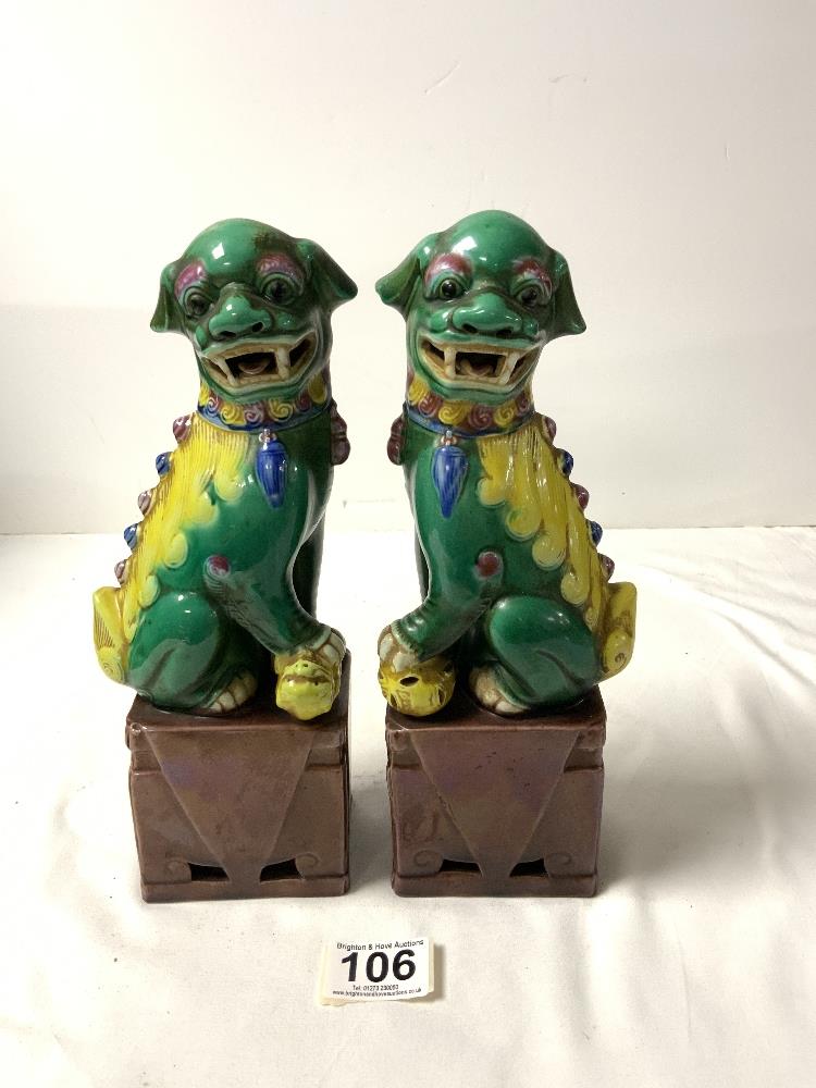 A PAIR OF CHINESE DOGS OF FOO, IN GREEN, YELLOW AND BROWN GLAZE, 26 CMS.