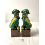 A PAIR OF CHINESE DOGS OF FOO, IN GREEN, YELLOW AND BROWN GLAZE, 26 CMS.