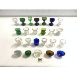 A COLLECTION OF 24 COLOURED AND CLEAR GLASS EYE BATHS.