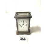 A BRASS CARRIAGE CLOCK WITH WHITE ENAMEL DIAL, [ WORKING ORDER AND KEY ]. 11.5 CMS.