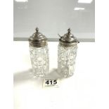 A PAIR OF HALLMARKED SILVER TOP CUT GLASS CONDIMENT BOTTLES, LONDON 1933.