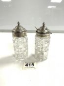 A PAIR OF HALLMARKED SILVER TOP CUT GLASS CONDIMENT BOTTLES, LONDON 1933.
