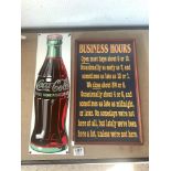 A REPRODUCTION ENAMEL COCA COLA SIGN, 53 CMS, AND BUSINESS OPENING HOURS BOARD.