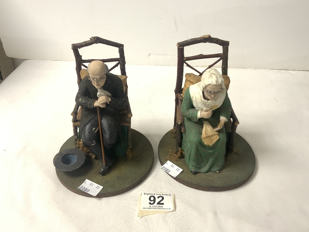 A PAIR OF WOODEN AND COMPOSITE NODDING FIGURES OF ELDERLY MAN AND LADY IN CHAIRS.