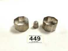 A PAIR OF HALLMARKED SILVER ENGRAVED NAPKIN RING, AND A HALLMARKED SILVER THIMBLE.53 GRAMS.