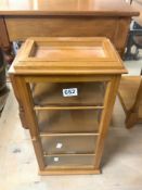 A SMALL RECTANGULAR GLAZED TRINKET DISPLAY CABINET, 26X58.