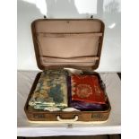A SUIT CASE OF MATERIAL, INCLUDES TABLE CLOTHES AND MORE.
