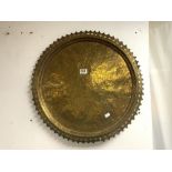 A CIRCULAR EASTERN BRASS TRAY WITH ENGRAVED DECORATION AND PIERCED BORDER, 60 CM DIAMETER.
