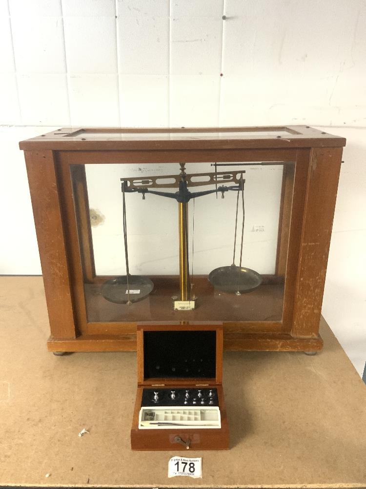 A SET OF CHEMISTS SCALES IN A GLAZED MAHOGANY CABINET, AND SET WEIGHTS IN CASE MAKER A. GALLENKAMP &