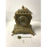 A LATE NINETEENTH CENTURY FRENCH ORNATE BRASS MANTEL CLOCK, WITH LION RING HANDLES AND CLAW FEET,