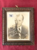A PORTRAIT PHOTOGRAPH OF BING CROSBY, IN A CARVED FRAME. 22 X 26 CM.