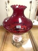 A VICTORIAN-STYLE OIL LAMP CONVERTED TO ELECTRIC, WITH A SATIN GLASS BODY AND RUBY GLASS SHADE, 54 X