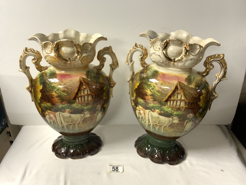 A PAIR OF LATE VICTORIAN CERAMIC VASE DECORATED WITH CATTLE AND MILKMAID, 35 CMS. A/F.