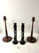 A PAIR OF MAHOGANY TURNED CANDLESTICKS, 31 CMS AND A PAIR OF WOODEN OPEN BARLEY TWIST CANDLESTICKS.