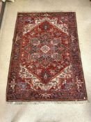 A PERSIAN DESIGN RED GROUND WOOLLEN RUG, 240 X 168 CM.