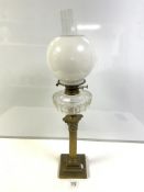 A LATE VICTORIAN BRASS CORINTHIAN COLUMN OIL LAMP, WITH CUT GLASS RESERVOIR AND WHITE GLASS SHADE,