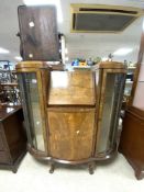 A 1930s BOW FRONTED WALNUT GLAZED BUREAU/CABINET ON BALL AND CLAW FEET.120X30X124 CMS.