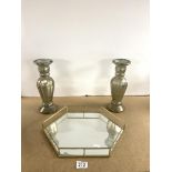 A PAIR OF SILVERED GLASS CANDLESTICKS, 30 CMS, AND A MIRRORED HEXAGONAL TRAY.