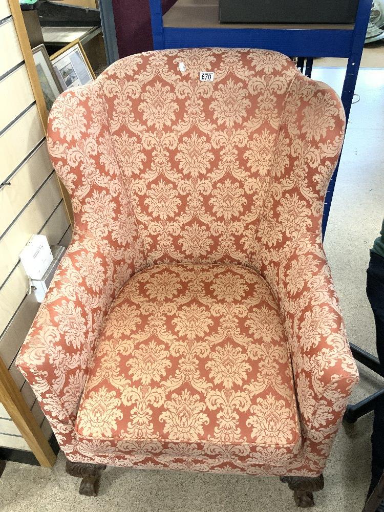UPHOLSTERED WING BACK ARMCHAIR ON CARVED BALL AND CLAW FEET.