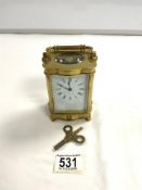 GOOD QUALITY BRASS CARRIAGE CLOCK WITH SHAPED BORDER, WHITE ENAMEL DIAL, IN WORKING ORDER AND WITH