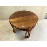 A WALNUT NEST OF SHAPED CIRCULAR TABLES ON BALL AND CLAW FEET, 68 CMS DIAMETER.