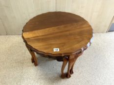 A WALNUT NEST OF SHAPED CIRCULAR TABLES ON BALL AND CLAW FEET, 68 CMS DIAMETER.