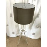 A MODERN WHITE WOODEN TRIPOD LAMP STAND AND SHADE.