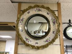 A BURLIEGH WARE CIRCULAR CERAMIC WALL MIRROR WITH FLORAL DECORATION AND ORNATE BRASS BORDE, 48 CMS