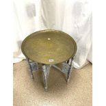 BENARES CIRCULAR BRASS TRAY ON CARVED FOLDING STAND, 59 CMS DIAMETER.