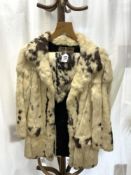 A VINTAGE WHITE SPOTTED FUR COAT BY CONNAUGHT FURS, DESIGNED BY CATHERINE GUILBERT OF PARIS.