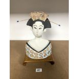 A JAPANESE STONEWARE POTTERY BUST, 33 CM, ON A MINIATURE OPIUM TABLE WITH A BLACK AND GOLD LACQUER